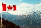 red and white flag on top of the mountain