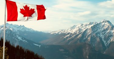 red and white flag on top of the mountain