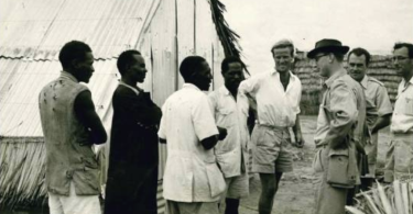 Settlers’ Irrigation Scheme at Hola Camp, Commandant Thompson, extreme right, looks on as visiting journalists and prisoners stand attentive in 1959.